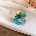 Vintage gold-plated cuff bracelet featuring a large blue enamel flower and petal design - Bangle / Eco Gold / Blue
