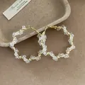 Elegant large gold hoop earrings wrapped with clear multifaceted crystal beads for women. - Twisted Style / Gold-White