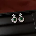 Detailed view of emerald green square zircon earrings presented in a luxury jewelry box. - Emerald / Silver Needle / Silver / Stud Earrings