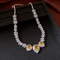 Macro view of vintage necklace featuring square yellow gems and white zirconia accents - Yellow / Silver / Necklace