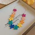 Primo piano della collana di fiori in rafia colorata con dettagli di petali intrecciati - Solo Catena / Colorato