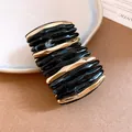 Detail of acrylic marbled spliced bracelet with elegant black and gold wavy texture. - Black