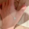 Elegante silberfarbene Halskette mit herzförmigem Zirkonia-Anhänger, auf der Hand gezeigt - Halskette / Weiß