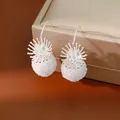 Detail of elegant white glass bead hook earrings with silver floral starburst design - Earring Hooks / White