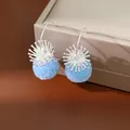 Detailed view of elegant light blue frosted bead earrings with silver sunburst decorative caps - Earring Hooks / Blue