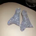 Primo piano dettagliato di orecchini geometrici scintillanti impreziositi da strass. - Oro