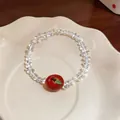 Detailed shot of a sweet beaded resin bracelet with a charming red apple pendant - Apple Pendant Beaded Bracelet / White/Red