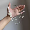 Detailed view of multilayer white beaded flower necklace with crystal charms on hand - Multi-layer Flower Necklace / White