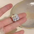 Detailed close-up of the sparkling zircon flower-shaped ear clip in 18k gold plating - Ear Cuffs / Silver