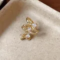 Macro detail of 18k gold plated triple bow ear cuff with sparkling pear-cut zirconias. - 18K Gold Plated / Gold Ear Bone Clip Single