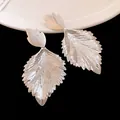 Detailed macro view of stylish silver pleated leaf drop earrings with metal texture - Wrinkled Leaf Style / Silver