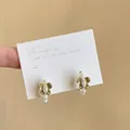 Close-up of elegant green floral enamel stud earrings with white pearls on a display card - Silver Needle Flower Style / Gold-White-Green