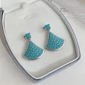 Exquisite detailed close-up of turquoise fan-shaped earrings presented in a white jewelry box. - Fan-Shaped (HE32907) / Silver Earring Post - Silver - Blue
