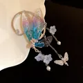 Detailed view of fairy-style resin butterfly wing earrings with floral tassels and pearls. - Wing Pendant / Blue