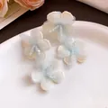Detail view of light blue and white mesh flower earrings with bead accents. - Stud Earrings (Silver Post) / Blue