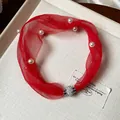 Vista dettagliata di un girocollo in rete rossa con perle e chiusura magnetica con strass - Rosso