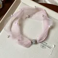 Dettaglio di collana girocollo in rete rosa con perle e chiusura magnetica - Rosa