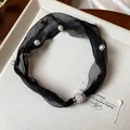 Dettaglio collana in rete nera con perle e una chiusura magnetica con strass brillanti - Nero