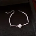 Vista ravvicinata di un bracciale in argento con un motivo centrale a cerchio. - Argento-Bianco