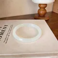 Détail d'un bracelet jonc en calcédoine blanche translucide sur un livre ancien - Style 3