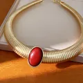 Dettaglio di una collana girocollo dorata a coste con grande pietra in resina rossa. - Collana in Resina Ovale / Oro-Rosso