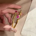Dettaglio del bracciale rigido dorato con zirconi rosa a forma di pera e un halo - Argento con Zirconia Rosa