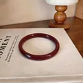 Bracelet jonc rond rouge foncé brillant élégant pour femme sur fond de livre - Style 4