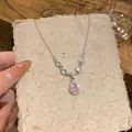 Dettaglio di una collana in argento con ciondolo in cristallo rosa su carta testurizzata - Argento-Rosa