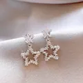 Vue détaillée de boucles d'oreilles pendantes en forme d'étoile argentée avec des zircons. - Argent