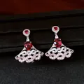 Close-up of fan-shaped drop earrings featuring red oval zircon and silver filigree - Silver Pin - Silver - Red