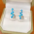 Detail shot of blue zircon and clear resin sphere stud earrings in a green velvet box - Silver Earring Post Style / Blue