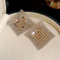 Close-up of geometric silver sequin mesh tassel earrings with metallic luster - Silver