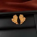 Macro view of elegant 18k gold plated heart stud earrings featuring sparkling white zircons. - Real Gold Plated Heart (HE34026) / Gold