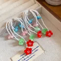 Close-up of multi-strand white seed bead earrings with colorful acrylic flower charms - Colorful