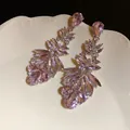 Close-up of elegant pink crystal drop earrings on a white decorative plate. - Silver Earring Post Style / Pink