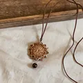 Detail of a vintage handcrafted rattan star pendant necklace with a leather cord - Octagram Star Style