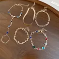 Detailed macro view of a 5-piece gold-tone bracelet set featuring colorful crystals. - Bracelet (5-Piece Set) / Gold (Colored 5-Piece Set)