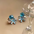 Close-up of blue starfish flower stud earrings with rhinestones and glass gems - Starfish Style (HE32339) / Silver Blue