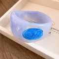 Detail van gemarmerde hars armband met een levendige blauwe emaille swirl - Meerblauw Lavendel Textuur Stijl / Meerblauw