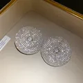 Detalle de los pendientes de botón redondos con cristales blancos brillantes - Plateado