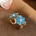 Detailed macro view of a vintage style blue enamel daisy cuff bracelet with pearls - Blue