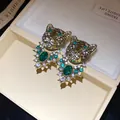 Close-up of vintage gold leopard stud earrings with green eyes and rhinestones - Leopard Head Style (HE33626) / Gold-Green