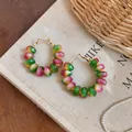 Close-up of macaron gradient beaded hoop earrings on minimalist canvas background - Beaded Hoop Style / Macaron Gradient Color