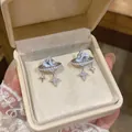 Close-up of 18K gold plated square starburst stud earrings in a luxury box - Silver