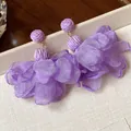 Macro detail of purple chiffon flower earrings with woven raffia balls - Purple