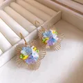 Nahaufnahme von eleganten hohlen Goldblumenohrringen mit bunten Perlenblumenmitten - Hohle Blume / Blau