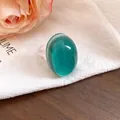 Close-up of a vintage oval resin ring with a turquoise translucent top and clear band. - Cyan