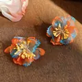 Detailed close-up of vibrant orange and blue chiffon flower earrings in natural light. - Flower Shape / Blue-Yellow-Orange