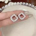 Macro view of elegant French-style diamond-shaped earrings with sparkling cubic zirconia - Rhombus Style (HE33272) / Silver