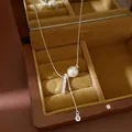 High-quality close-up of a silver lariat necklace featuring a pearl and textured bar pendant - Silver-Pale Yellow